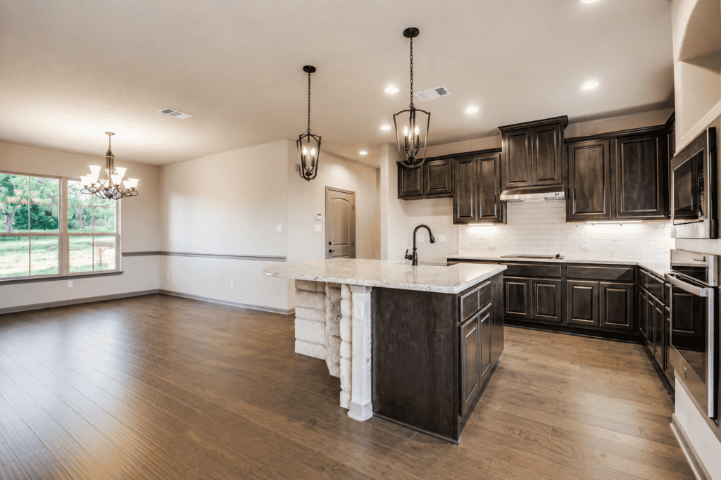Kitchen with dark wood cabinets and granite island in the 1115 Barolo Court custom home